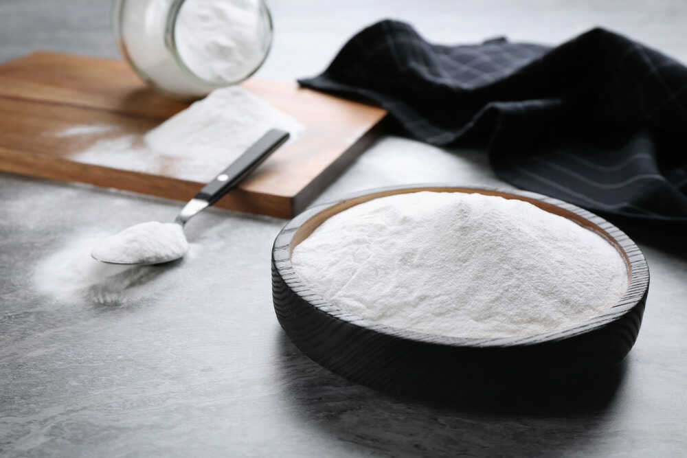 Baking soda in plate on grey table