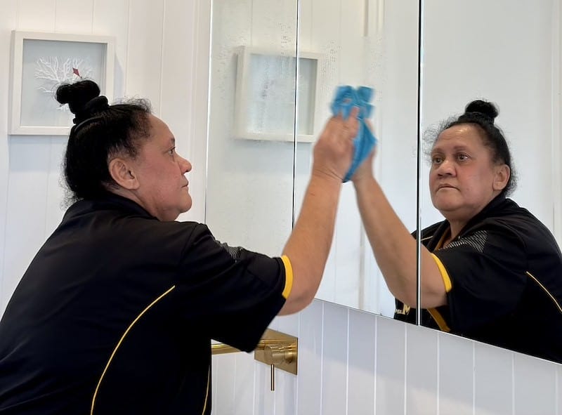 Cairns cleaner wiping bathroom mirror in a customer's home