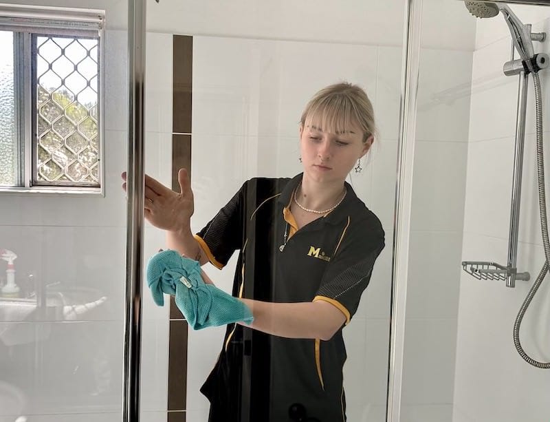 Maid2Match professional cleaner Casey cleaning a client's shower