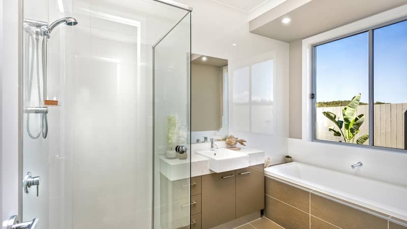 Clean bathroom featuring a glass shower area, a basin with cabinets, and a bathtub