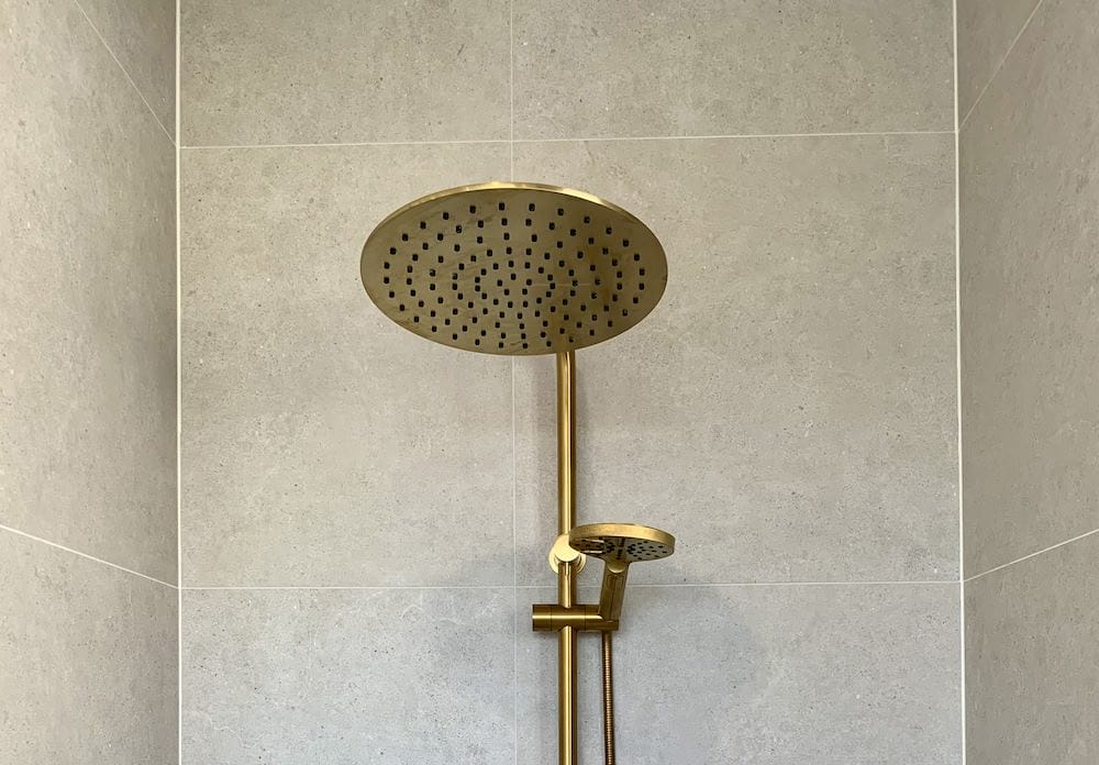 clean porcelain shower tiles and shower head