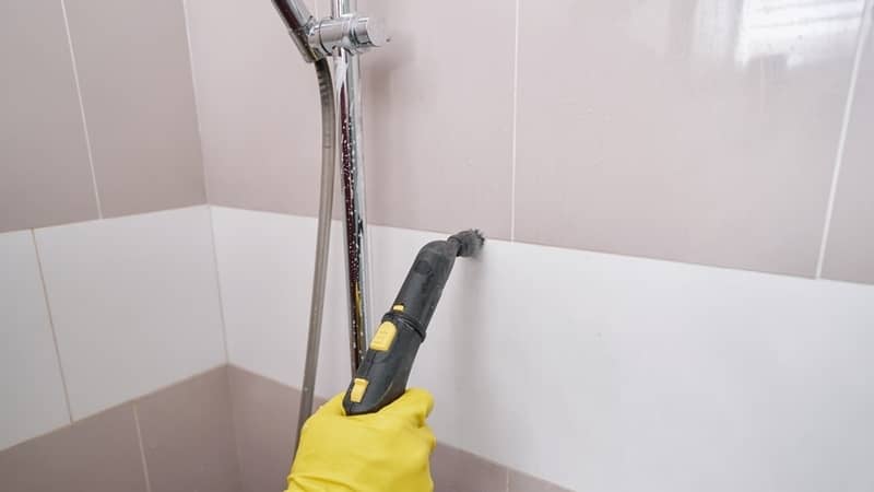 steam-cleaning grout line on wall