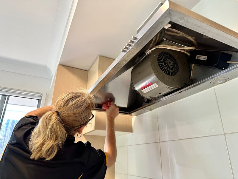 professional cleaning wiping the inside of a rangehood