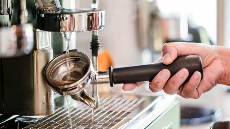 cleaning coffee machine in coffee shop