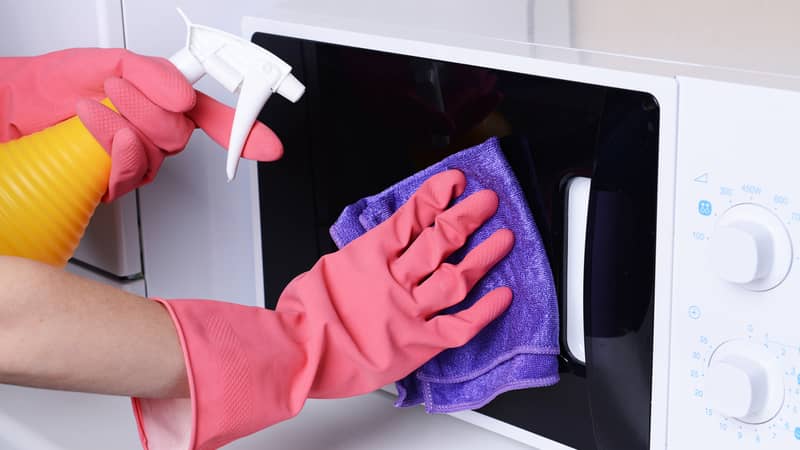 Cleaning microwave oven in kitchen close-up