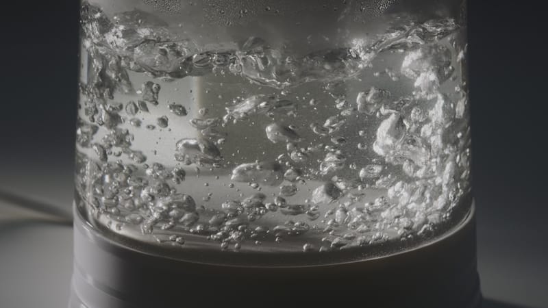 close up of boiling liquids inside a glass kettle 