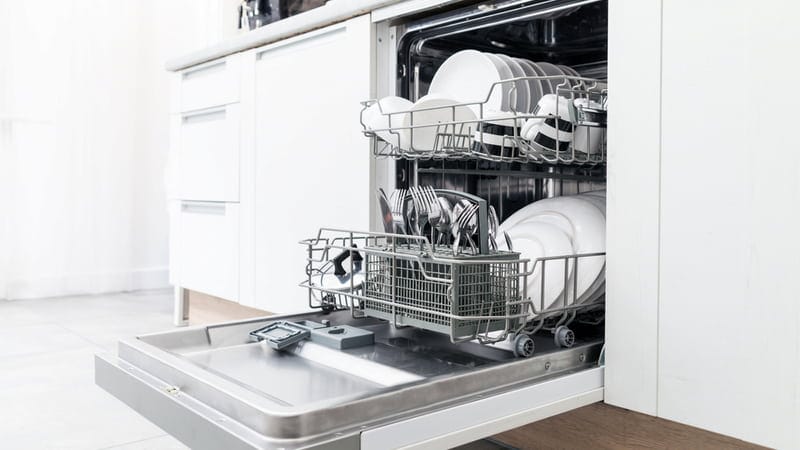 Open dishwasher with clean dishes in the white kitchen