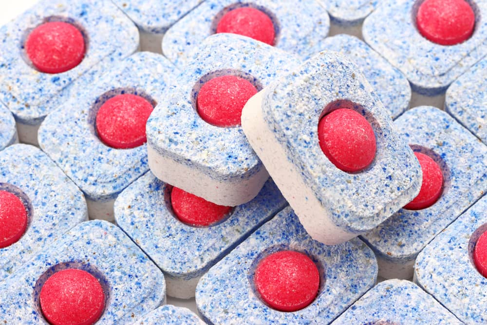 Blue dishwashing tablets with red power balls stacked together