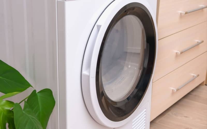 White front loading dryer in a laundry room