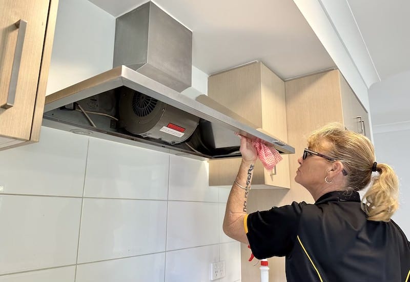 Professional house cleaner Elizabeth cleaning inside a customer's rangehood