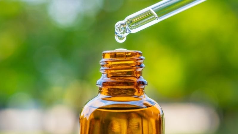 pouring essential oil into amber bottle