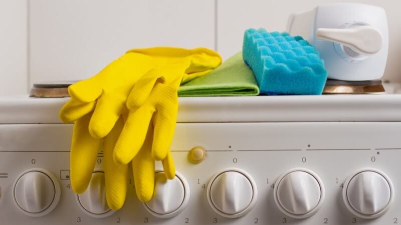 gloves sponge and detergent on a stove