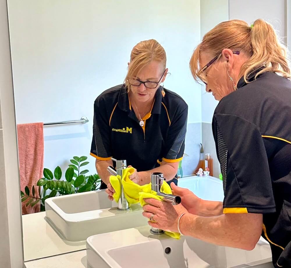 house cleaner cleaning the bathroom sink in a client's home