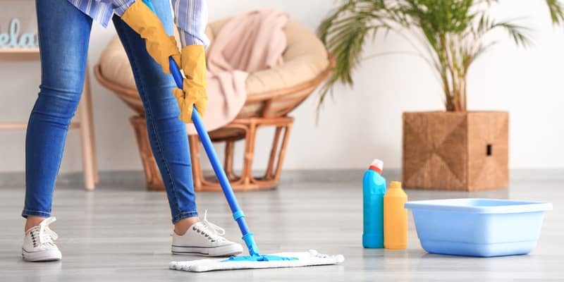 Woman mopping floor in room