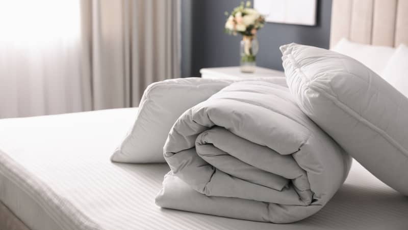 folded doona stacked with pillows