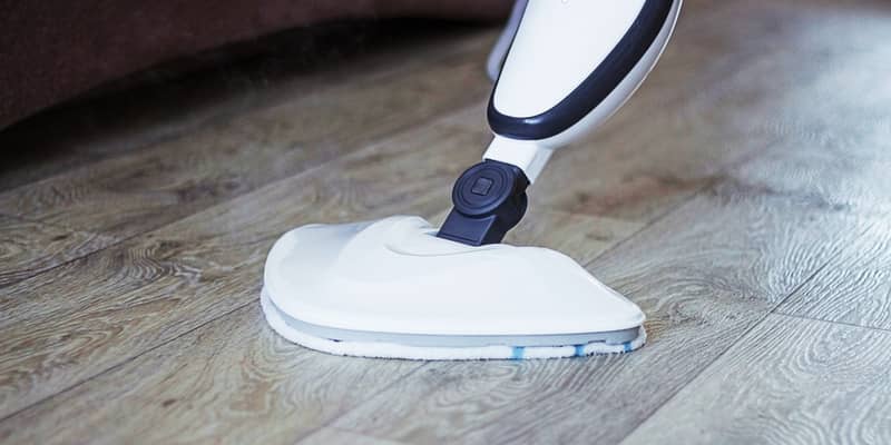 Cleaning the floor with a steam mop cleaner