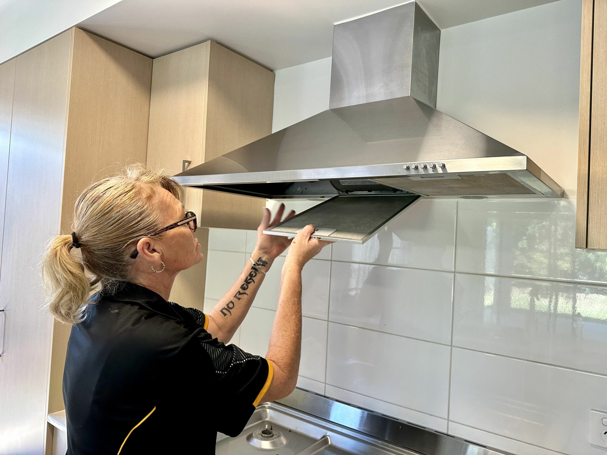 woman cleaning rangehood filters