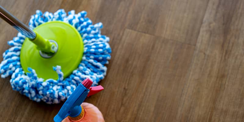 Top view over wood planks vinyl flooring with set of mopping cleaning items on copy space