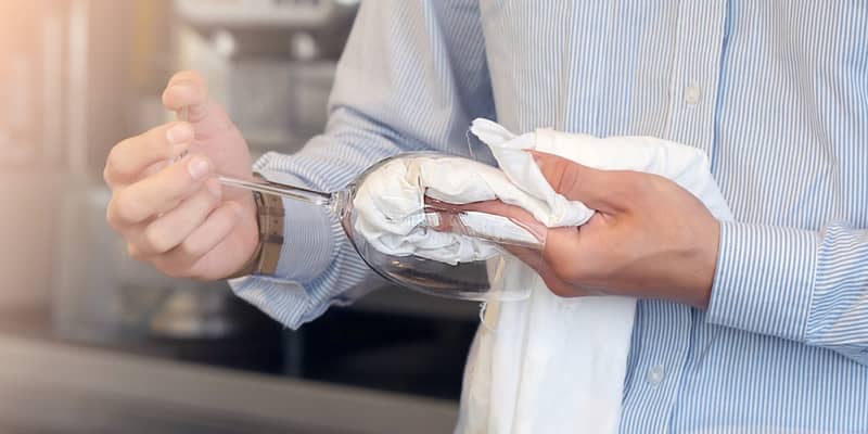 male hands wiping the wine glasses