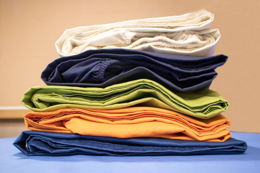 Ironed pile or stack of colorful fitted sheets, freshly washed, folded and stacked