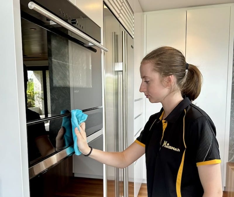 Jade wiping the exterior of kitchen appliances