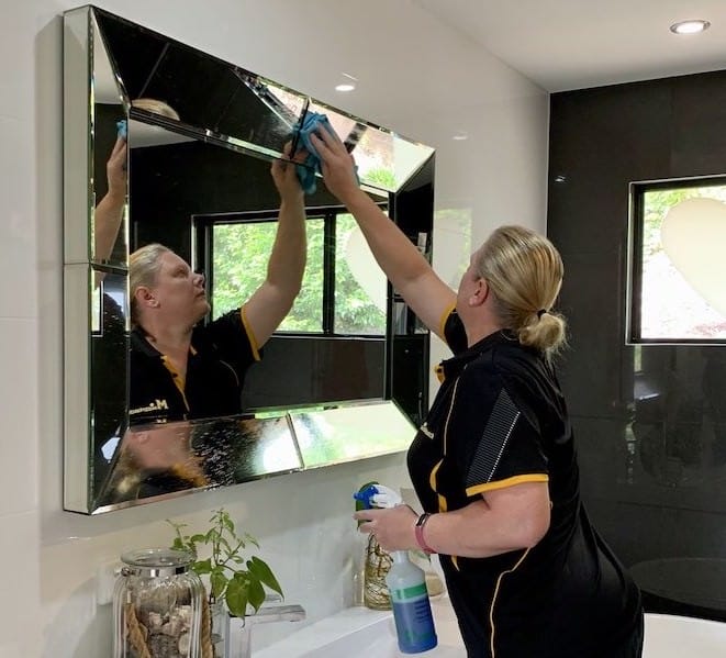 Geelong cleaner wiping a bathroom mirror