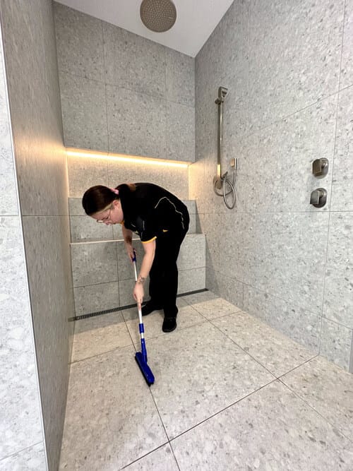 Kirsten scrubbing tile grout in the shower