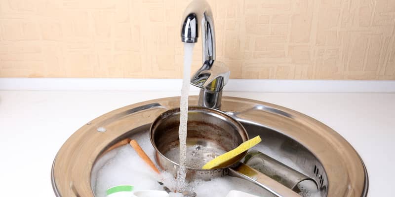 Utensils soaking in kitchen sink