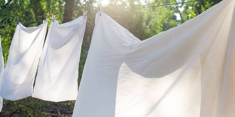 white bedding, clothesline drying, hanging outside