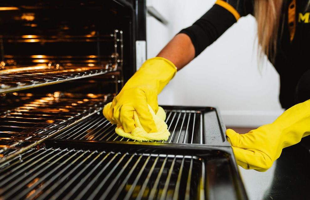 Professional cleaner wiping an oven