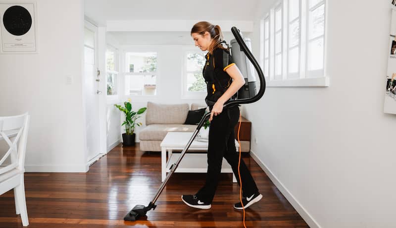 professional cleaner cleaning living room with vacuum 