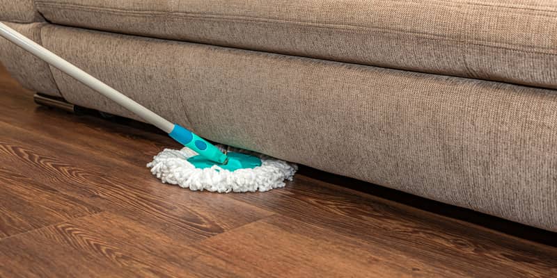 Cleaning vinyl brown floor with a round mop.