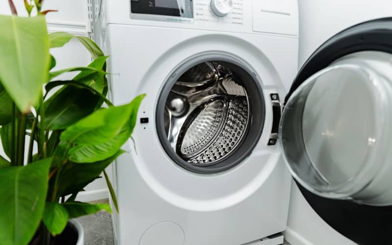 front load washing machine with open door in laundry room