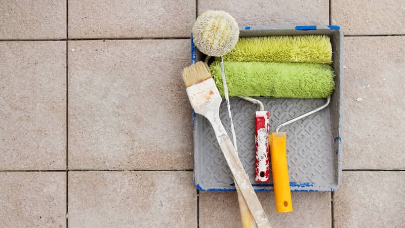 Painting tools over stone floor tile background. 