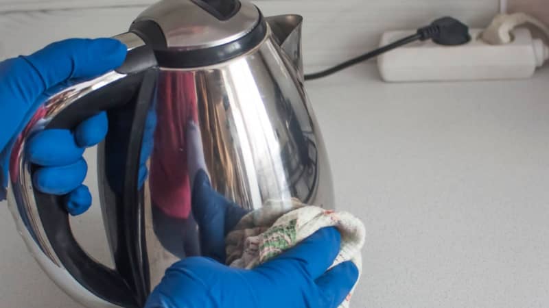 woman wipes the kettle with cloth