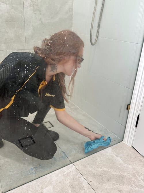 professional wiping the shower glass