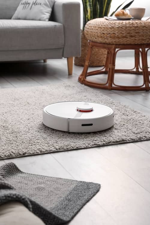 Modern robot vacuum cleaner on soft carpet in room