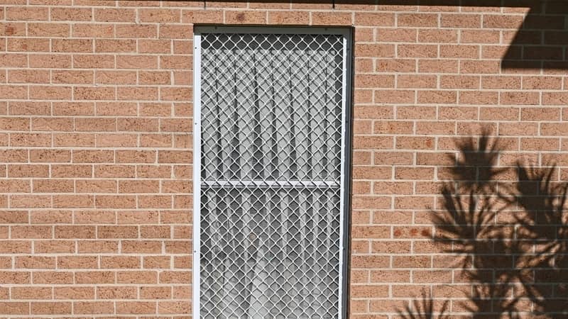 Metal security screen on a window in a brick building