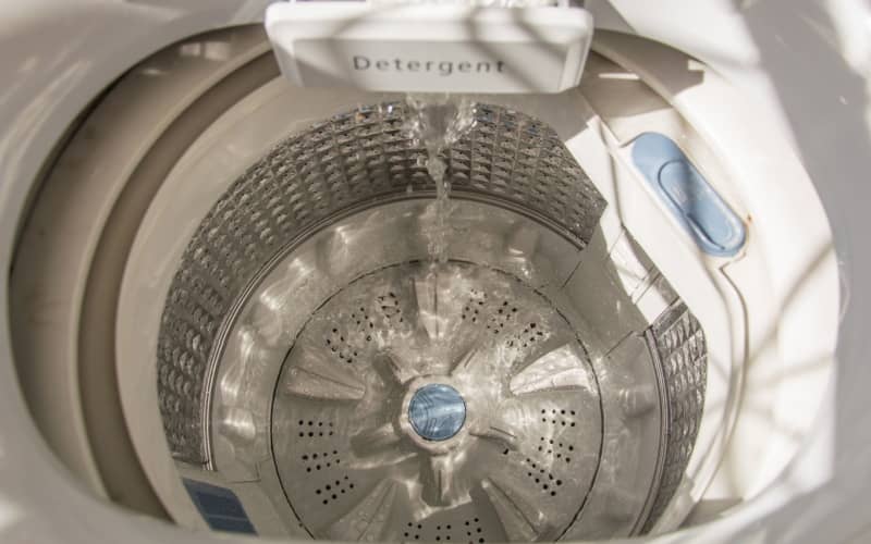 top view of a top load washing machine with water pouring in