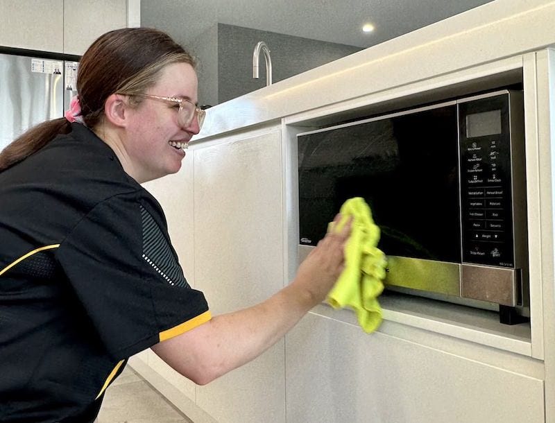 Tweed Heads cleaner wiping a customer's microwave