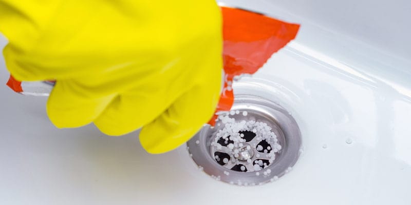  Cleaning the plughole of a ktichen sink to unblock the drain