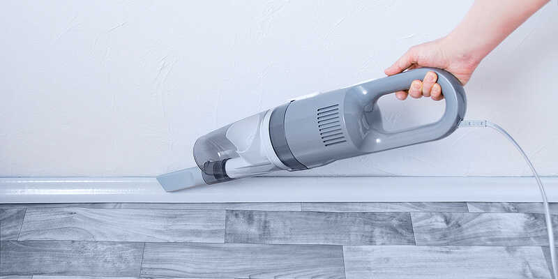 cleaning the skirting board with a vacuum cleaner