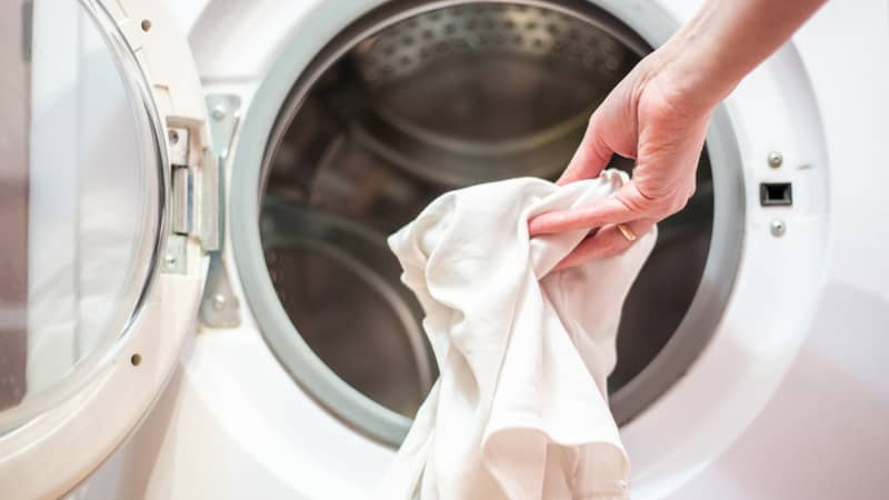 open door of the washing machine with dirty laundry