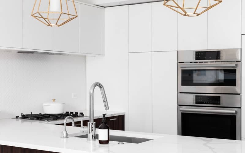 Polyurethane cabinets above the stove in white modern kitchen