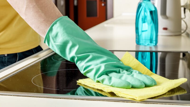 wiping a glass stove top cooker with a microfibre cloth