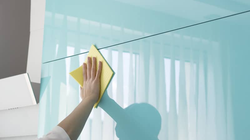 woman in the kitchen doing housework cleaning cupboards.